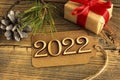 happy new year wooden numbers 2022 on craft tag on brown old wood, congratulations