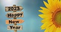 2023 happy new year written on a direction sign with petals of sun flower Royalty Free Stock Photo