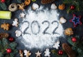 Happy New Year 2022 written on flour and Christmas Decorations Gingerbread cookies. New Year greeting card Royalty Free Stock Photo