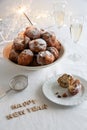 Happy New Year written with small letters and a bowl of traditional oliebollen (Dutch dough fritters) with sparklers