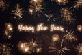 Happy New Year written with sparkle fireworks on night sky