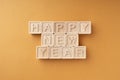 Happy New Year is written on wooden cubes. Wooden cubes with letters on an orange background. New Year`s card Royalty Free Stock Photo