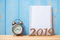 2019 Happy New years with notebook, retro alarm clock and wooden number on table and copy space. Royalty Free Stock Photo