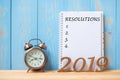 2019 Happy New years with Resolution text on notebook, retro alarm clock and wooden number on table and copy space Royalty Free Stock Photo