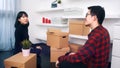 Happy newlywed asian couple unpacking cardboard boxes in new apartment Royalty Free Stock Photo