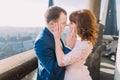 Happy newlywed bride and groom kissing on the balcony of old gothic cathedral Royalty Free Stock Photo