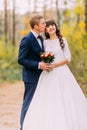 Happy newlywed bride and groom posing in the autumn pine forest Royalty Free Stock Photo