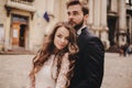 Happy newlywed couple hugging and kissing in old European town street, gorgeous bride in white wedding dress together with Royalty Free Stock Photo