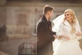 Happy newlywed groom hugging blonde beautiful bride from behind Royalty Free Stock Photo