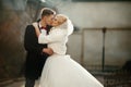 Happy newlywed groom hugging and kissing blonde beautiful bride Royalty Free Stock Photo