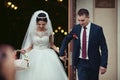 Happy newlywed romantic couple coming out of church after wedding ceremony with a candy basket Royalty Free Stock Photo