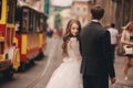 Happy newlyweds couple on a walk in old European town street, gorgeous bride in white wedding dress together with handsome groom Royalty Free Stock Photo