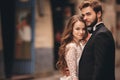 Happy newlyweds couple on a walk in old European town street, gorgeous bride in white wedding dress together with handsome groom Royalty Free Stock Photo