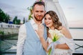 happy newlyweds exchange rings. beautiful wedding ceremony by water on dock.