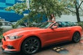 Happy newlyweds go to the celebration in a red car with an open top. Wedding Concept Royalty Free Stock Photo