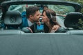 Happy newlyweds go to the celebration in a red car with an open top. Wedding Concept Royalty Free Stock Photo