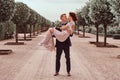 Happy newlyweds. Handsome groom holds his charming bride in her arms in the amazing garden.