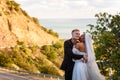 Happy newlyweds kiss against the backdrop of a beautiful mountain landscape, a girl kisses a guy