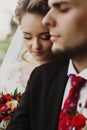 Happy newlyweds portrait, romantic couple, blonde bride with bouquet and handsome groom in stylish black suit posing outdoors, be Royalty Free Stock Photo