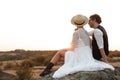 Happy newlyweds sitting on rock Royalty Free Stock Photo