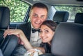 Happy newlyweds in a wedding car