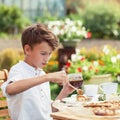 Happy nice boy drinking tea in summer green garden Royalty Free Stock Photo