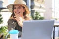 Happy nice woman working on laptop in street cafe Royalty Free Stock Photo