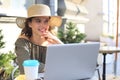 Happy nice woman working on laptop in street cafe Royalty Free Stock Photo