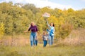 Happy non traditional family of two young mother and their kids launch a kite on nature at sunset