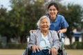 happy nurse take care and pushing senior woman in wheelchair at park, friendly caregiver Royalty Free Stock Photo