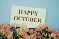 Happy October text with flower frame on blue background