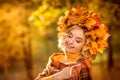 Happy old age. Portrait of a cheerful elderly woman with yellow autumn leaves in her hands, walking in the park Royalty Free Stock Photo