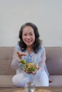 Happy old asian woman eating fresh green salad. Senior woman good healthy at home. Exercise and healthy diet concept Royalty Free Stock Photo