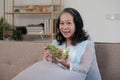 Happy old asian woman eating fresh green salad. Senior woman good healthy at home. Exercise and healthy diet concept Royalty Free Stock Photo
