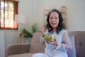 Happy old Asian woman eating fresh green salad. Senior woman good healthy at home. Exercise and healthy diet concept Royalty Free Stock Photo