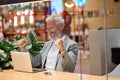 Happy old business man looking at laptop celebrating betting win online. Royalty Free Stock Photo