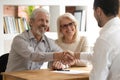 Happy old couple clients make financial deal handshake meeting lawyer Royalty Free Stock Photo