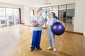 Happy old couple holds basketball and pilates ball Royalty Free Stock Photo