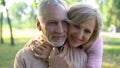 Happy old couple hugging, resting in park together, grandparents closeness