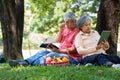 Happy old elderly couple spouses relaxing and sitting on a blanket in the park and sharing few precious memories. Senior couple Royalty Free Stock Photo