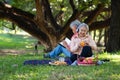 Happy old elderly couple spouses relaxing and sitting on a blanket in the park and sharing few precious memories. Senior couple Royalty Free Stock Photo