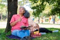 Happy old elderly couple spouses relaxing and sitting on a blanket in the park and sharing few precious memories. Senior couple Royalty Free Stock Photo