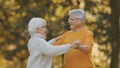 Happy old enjoying day in park. Senior man flirting with elderly woman. Dance in autumn day Royalty Free Stock Photo