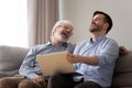 Happy old father and young son laughing using laptop together Royalty Free Stock Photo