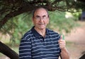 Happy old grandfather enjoying life waving hi, with big smile, big glasses and confident abuelo