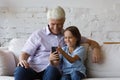 Happy old grandfather and small kid using cellphone. Royalty Free Stock Photo