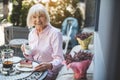 Smiling elderly woman enjoying tea outdoors Royalty Free Stock Photo