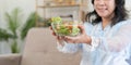 Happy old lady eating fresh green salad, smiling at home Royalty Free Stock Photo