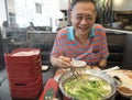 Happy old man eating a shabu shabu (hot pot)