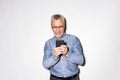 Happy old man in blue shirt using smartphone isolated Royalty Free Stock Photo